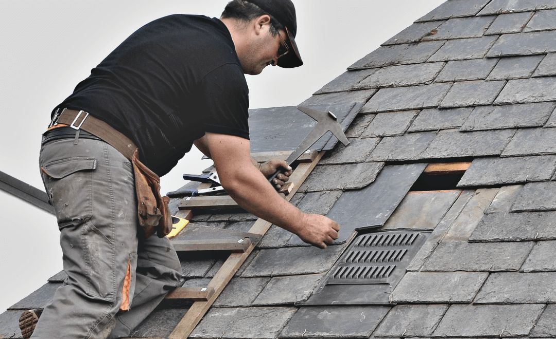 Roofer replacing a damaged section near the ridge on Raj's roof in Woodridge