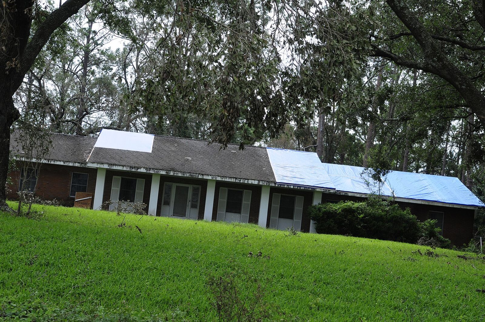House in Plainfield with a tarp on the damaged slope the evening after a hailstorm