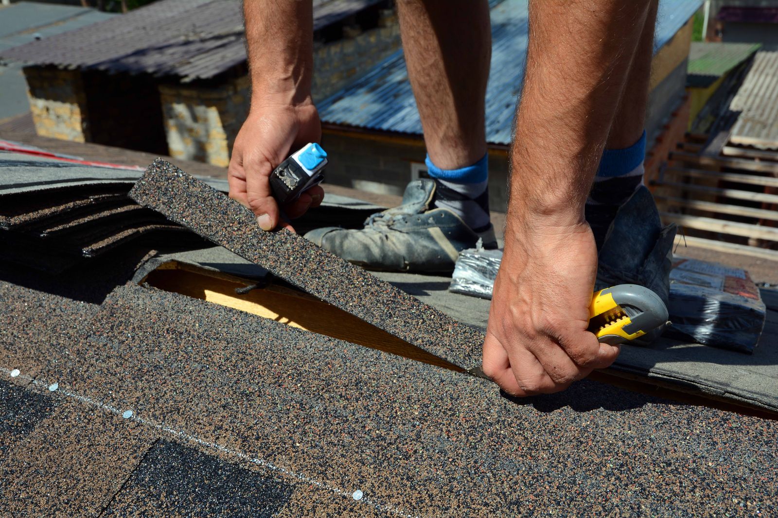 Elm Street Roofing crew member nailing architectural shingles